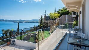A balcony with a glass railing overlooking a scenic view of a lake and mountains. - Aithra Seaview Suite by Konnect (Barbati)