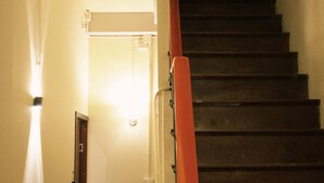A staircase with a handrail, a door, and a light fixture. - Room with a Temple View (Phra Nakhon)