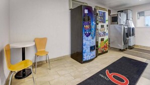 A small room with a table and two chairs, a vending machine, and a microwave. - 2 Full Beds | Non-Smoking (Grants)