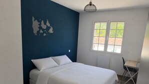 Ein Schlafzimmer mit einem Bett, einem Fenster und einem Stuhl.