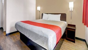 Quarto de hotel com cama, mesas de cabeceira e luzes fixadas na parede.