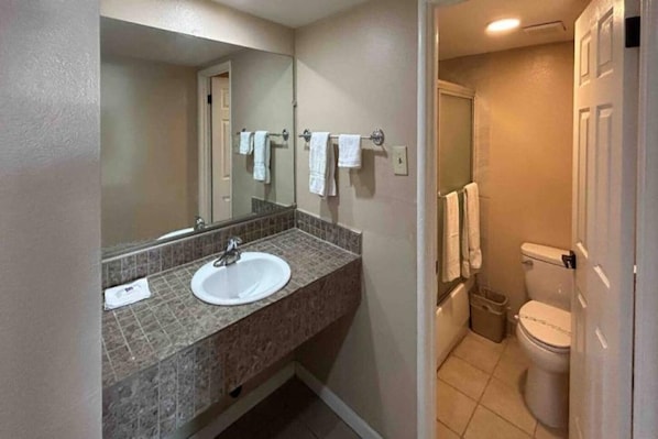 A bathroom with a sink, mirror, and toilet.