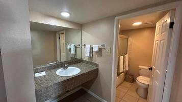 A bathroom with a sink, mirror, and toilet.