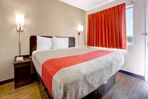Ein Hotelzimmer mit einem Bett, einem Nachttisch und zwei Wandleuchten.
