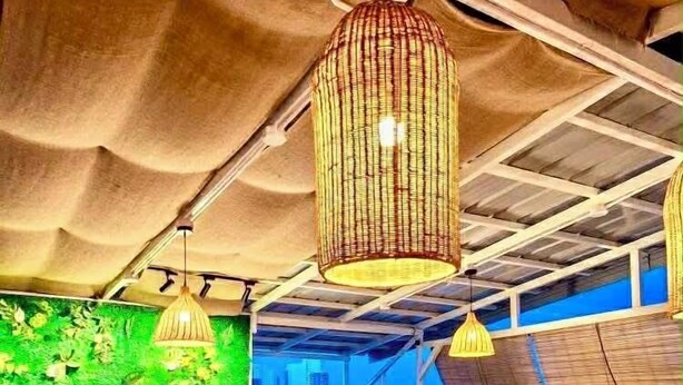 A modern interior with a green wall, seating areas, and hanging lights. - The Upperhouse Hotel Boutique Stay with City & River Views (Cagayan de Oro)