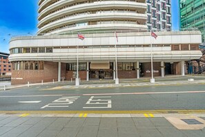 A multi-story building with a curved facade, a central entrance with a canopy, and two flags on poles. - Atlantic Tower Hotel By Sunday - Superior Double Room (Liverpool)
