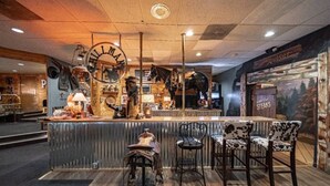 L’intérieur d’un restaurant, avec un bar, un plancher en bois et un panneau affichant le menu, notamment des steaks.