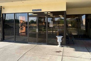 A building entrance with a glass door, a sign reading 'Entrance,' and a number '133' on the door.