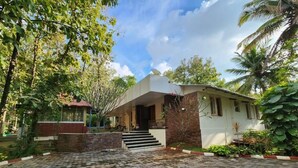 Una casa con entrada empaveda, pared de ladrillo y una escalera que lleva a la puerta.