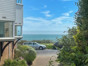 Ein Wohngebiet mit Blick aufs Meer, ein geparktes Auto und ein Gebäude mit Balkon.