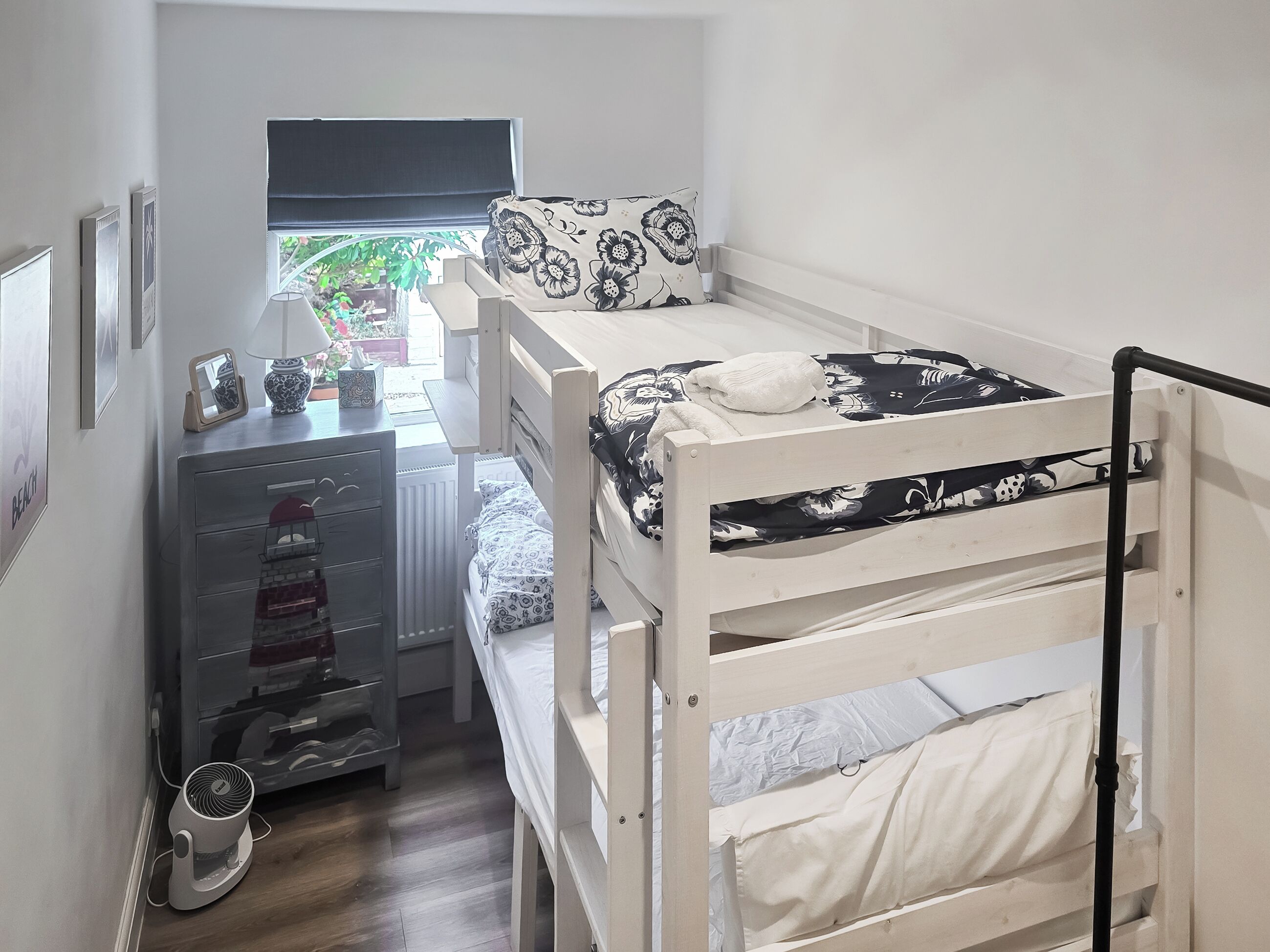 A bunk bed with a desk and a radiator.
