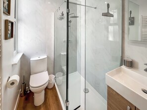 A modern bathroom with a glass-enclosed shower, a white toilet, and a sink. - Vikings Shore - UK50995 (Broadstairs)