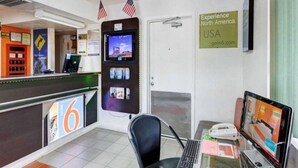 Un espace d’accueil comprenant un comptoir, un ordinateur et un panneau publicitaire encourageant les voyages en Amérique du Nord.