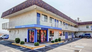 A motel with a two-story structure, a parking lot, and a 'Welcome' sign. - 2 Full Beds | Smoking (St George UT)