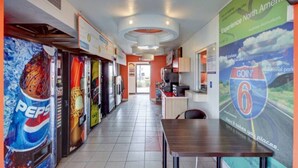 A corridor with vending machines, a table, and a wall with a 'Goin' 6' sign. - 2 Full Beds | Smoking (St George UT)