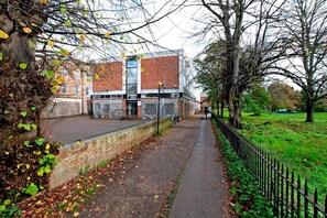 A pathway leading to a building with a brick facade and a glass section. - Winchester Wessex Hotel by Sunday Double Room (Winchester)