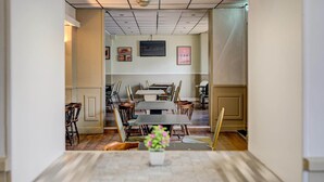 Una sala de conferències amb una taula llarga, cadires i una televisió penjada a la paret.