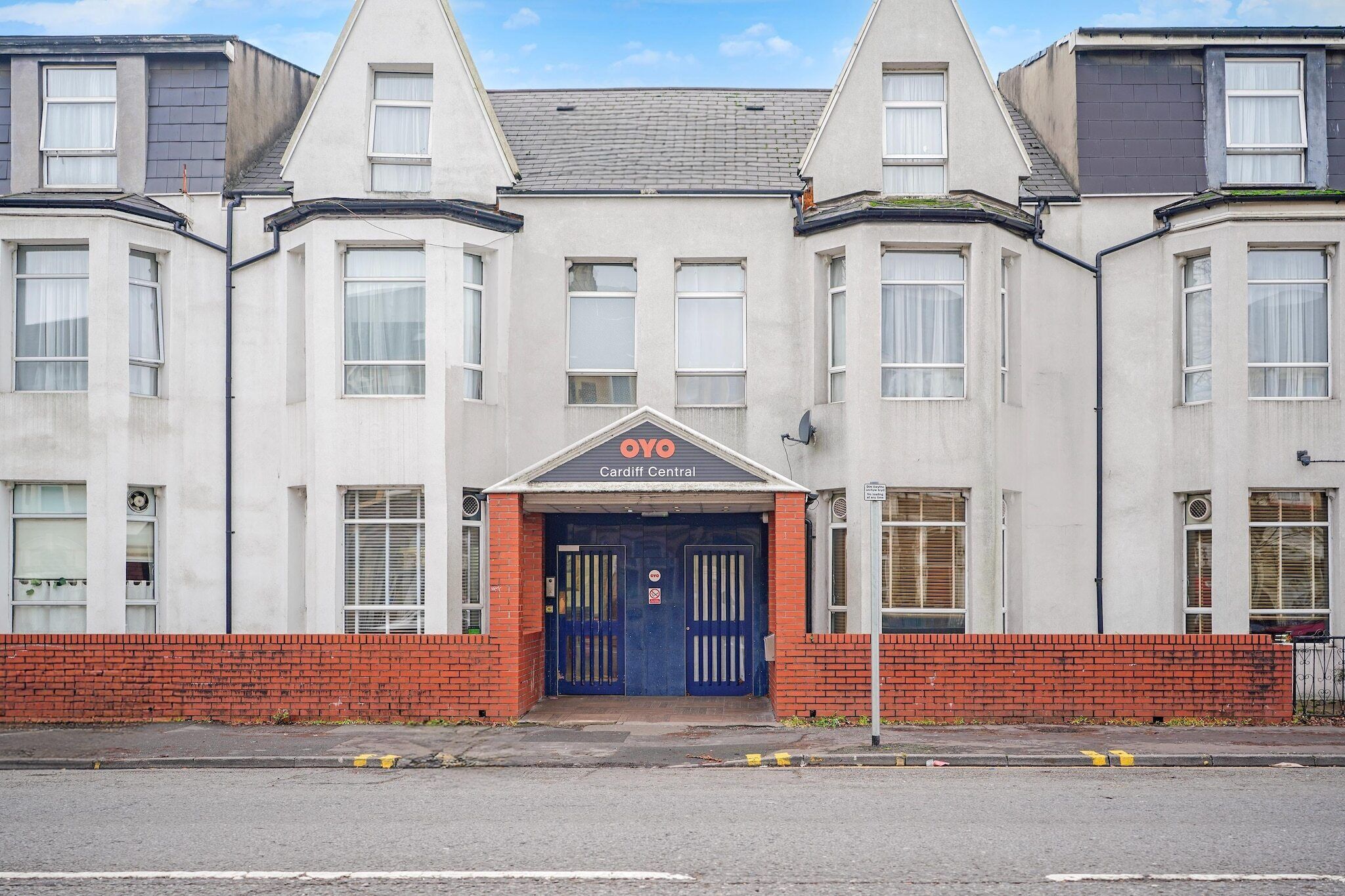 Un bâtiment doté d’une entrée principale, de nombreuses fenêtres et d’une enseigne indiquant « OYO Cardiff Central ».