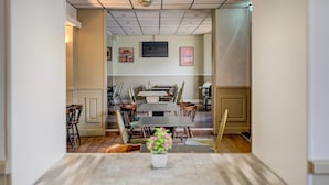 A conference room with a long table, chairs, and a television screen on the wall. - Standard Single Room (Cardiff)