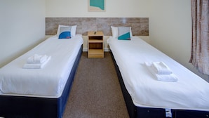 A hotel room with two single beds, a small wooden nightstand, and a wall-mounted artwork. - Standard Single Room (Cardiff)