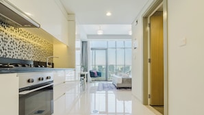 A modern kitchen with a stove, oven, and a patterned backsplash. - PVH - Aykon City - Canal View Studio  (Dubai)
