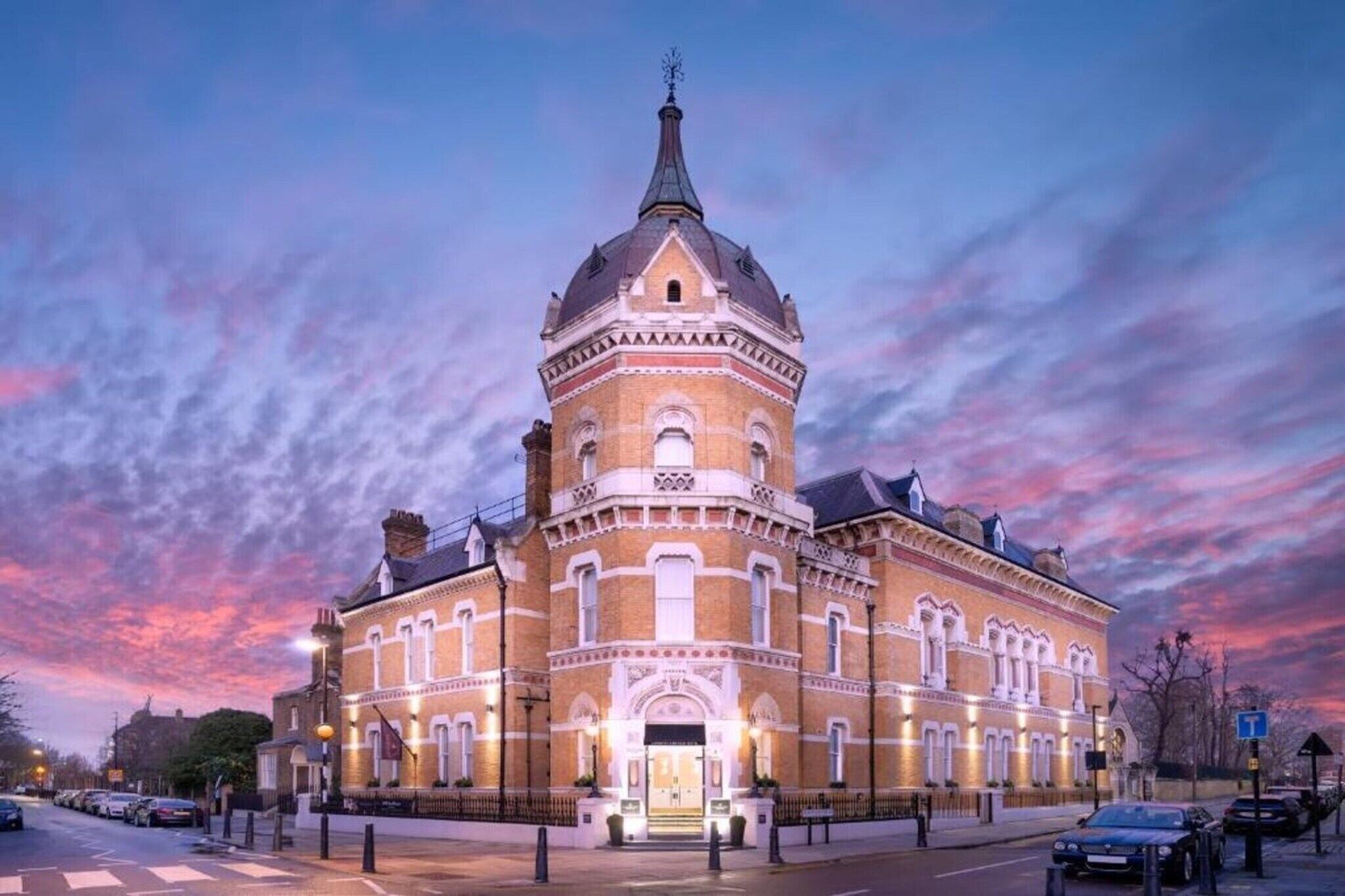 A historic building with a prominent tower, large windows, and a well-lit entrance.