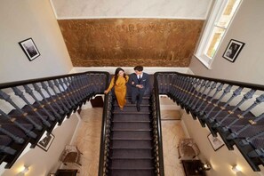 Eine prachtvolle Treppe mit Marmorstufen und einer verzierten Wand.