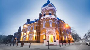 A large, ornate building with a prominent dome and multiple windows, likely a historical or cultural landmark.