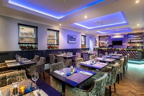 Ein Restaurant mit mehreren Tischen, Stühlen und einer Bar.