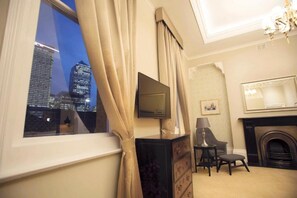 A hotel room with a city view, a fireplace, a television, and a desk with a chair. - Lansbury Studio Suite (London)