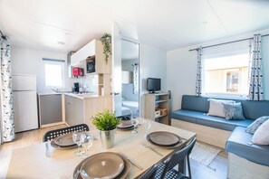 Un espace de vie compact comprenant un coin repas, une kitchenette et un coin salon.