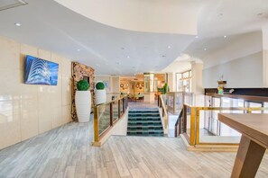 A modern hotel lobby with a marble floor, a staircase with glass railings, and a view of the interior. - Atlantic Tower Hotel By Sunday - Classic Double room (Liverpool)