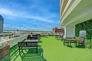 A rooftop terrace with green artificial grass, outdoor seating, and a view of the city skyline. - Atlantic Tower Hotel By Sunday - Classic Double room (Liverpool)