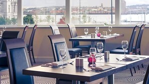 Een restaurant met gedekte tafels, stoelen en wijnglazen.