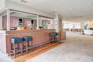 A bar area with a counter, stools, and a view into a room with a bar and seating. - Atlantic Tower Hotel By Sunday - Classic Double room (Liverpool)