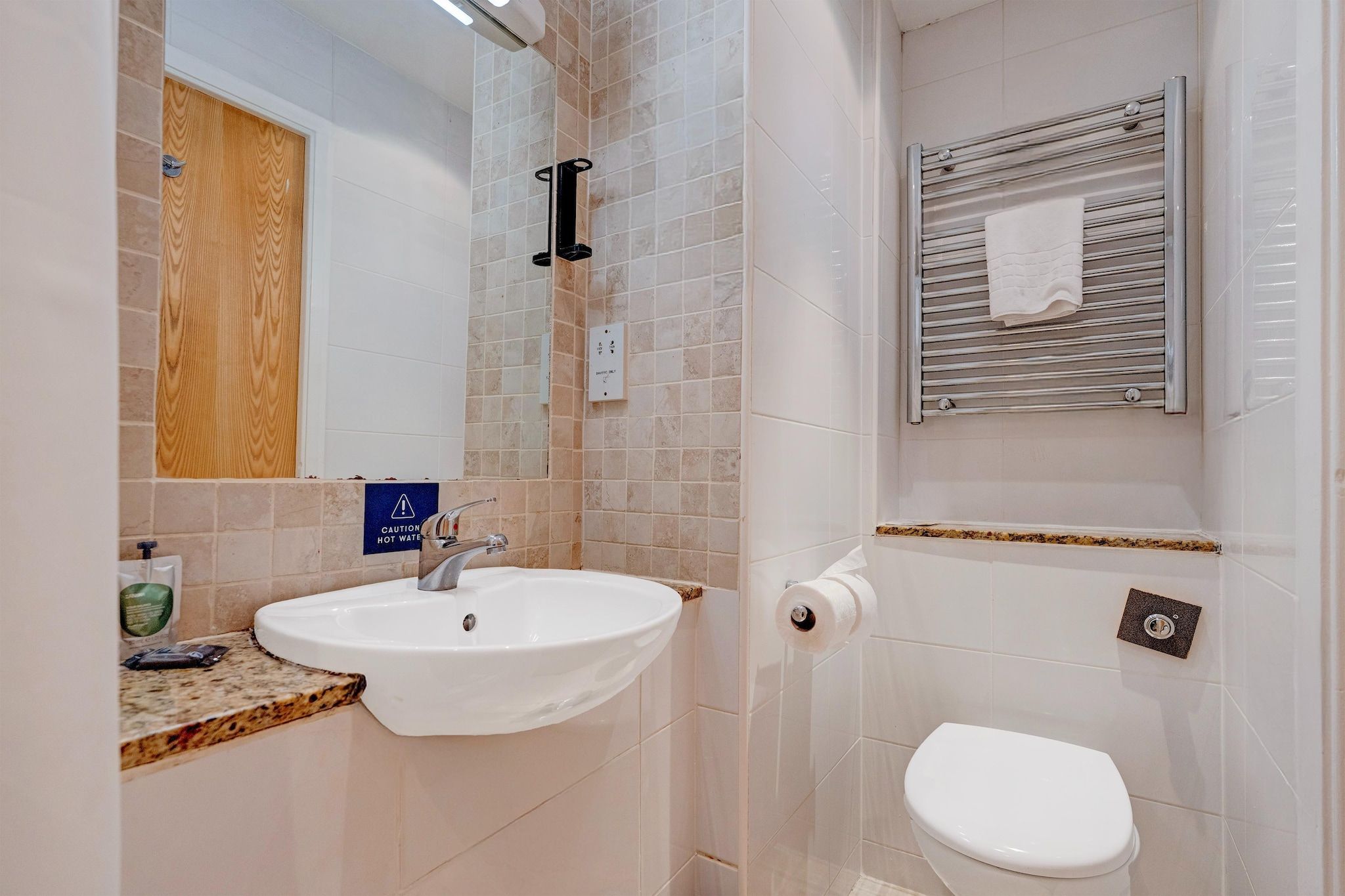 A bathroom with a sink, toilet, and a towel rack.