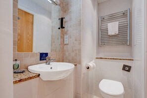 A bathroom with a sink, toilet, and a towel rack.