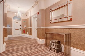 A hotel lobby with a grand staircase, a chandelier, a fire extinguisher, and a mirror on the wall. - Superior Double Suite (Liverpool)