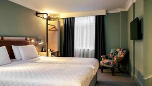 A hotel room with a bed, a chair, a coat rack, a television, and a window with curtains. - Bristol Grand Hotel By Sunday - Standard Twin Room (Bristol)