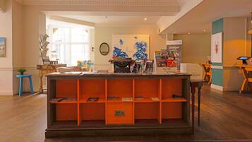 A reception area with a wooden desk, a typewriter, and a bookshelf.