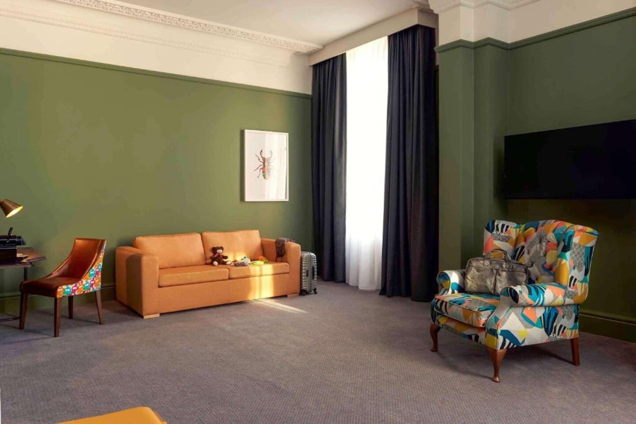 A living room with a sofa, armchair, and a flat-screen TV.
