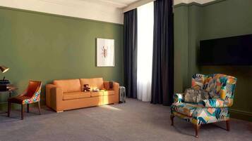 A living room with a sofa, armchair, and a flat-screen TV.