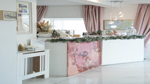 A reception desk with a marble counter, framed pictures, and a sign for a restaurant. - Standard Double Room (Newquay)