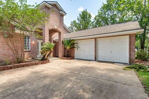 A residential house with a brick facade, a garage, and a driveway.