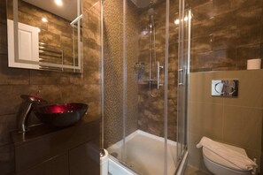 A modern bathroom with a glass-enclosed shower, a large mirror, and a black vessel sink. - Standard Single Room (Newquay)