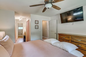A bedroom with a bed, a ceiling fan, a TV, and a dresser. - Pool & Dual Decks! Modern Trinity River Retreat (Lewiston)