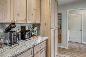 A kitchen with wooden cabinets, a coffee maker, and a microwave.