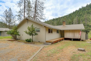 A single-story house with a front porch, a chimney, and a small deck. - Pool & Dual Decks! Modern Trinity River Retreat (Lewiston)