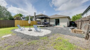 A backyard with a patio, outdoor seating, and a covered area. - Private Yard & Deck! Group-Friendly Haven in Manor (Manor)