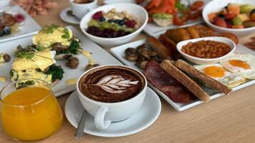 A breakfast setting with various dishes, including eggs, toast, and a cup of coffee with latte art.